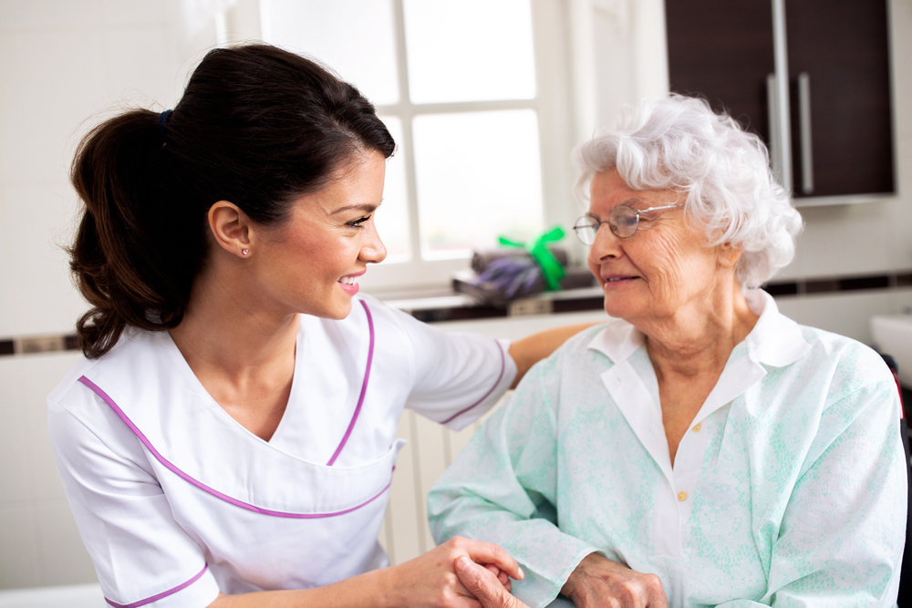 Nurse attending senior woman in a long term care facility, concept of trust between medical staff and home occupants